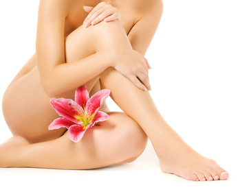 Female legs with pink lily isolated on white background